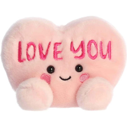 Straight front view of the sitting pale pink plush heart showing the embroidered LOVE YOU text, black eyes, and rosy pink cheeks.