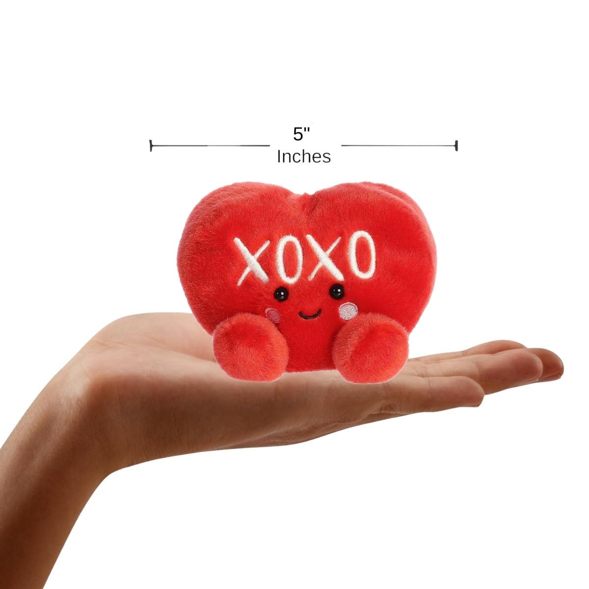 Sizing graphic showing the 5-inch Palm Pals XOXO Candy Heart plush sitting perfectly in the palm of a hand to demonstrate its small scale.
