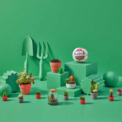 A lifestyle scene showing multiple completed mini potted plants arranged neatly across a bright green tiered background.