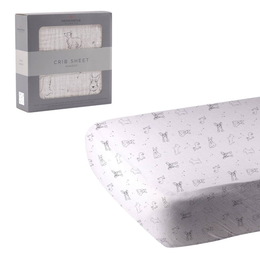 Newcastle Classics Corgi and Scottie puppy print bamboo crib sheet unrolled next to its grey retail window box.