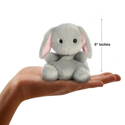 Sizing graphic for the Aurora Palm Pals Pebbles Bunny plush showing it sitting perfectly in the palm of a hand, indicating a total height of 5 inches.