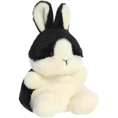 Angled front view of the soft black and white Palm Pals bunny plush sitting upright.