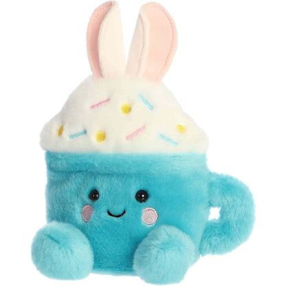 Angled view of the sweet Palm Pals Lopi Bunny Latte plush looking slightly to the left, showing its right blue foot.