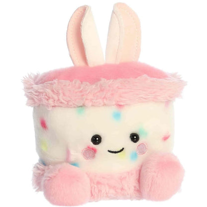 Angled front view of the adorable Aurora Bubbi Bunny Cake stuffed animal featuring a sweet smile, rosy pink cheeks, dark eyes, and soft pink feet.