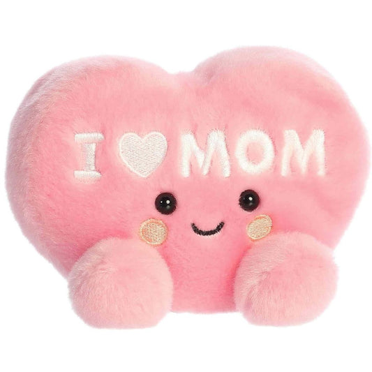 Angled front view of the soft pink Palm Pals I Love Mom Heart stuffed toy sitting upright.