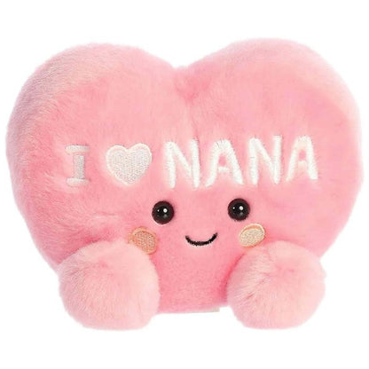Angled front view of the soft pink Palm Pals I Love Nana Heart stuffed toy sitting upright.
