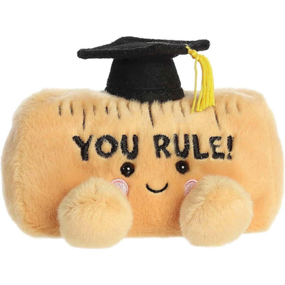 Straight front view of the sitting plush ruler showing the embroidered YOU RULE text, tick marks, and rosy cheeks.