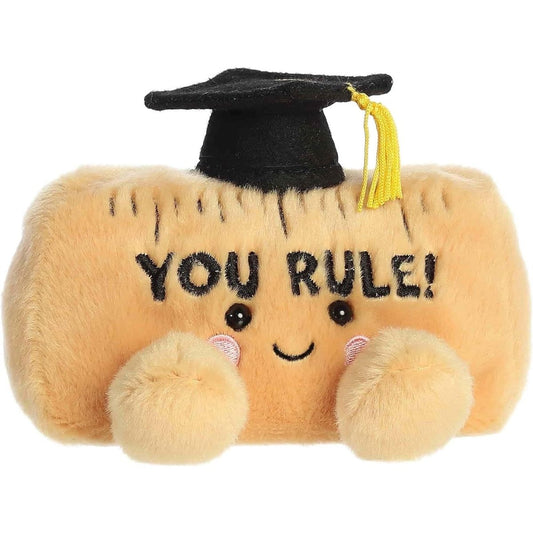 Straight front view of the sitting plush ruler showing the embroidered YOU RULE text, tick marks, and rosy cheeks.