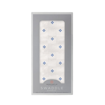 Straight front view of the packaged Periwinkle Diamond Polka Dot swaddle blanket in a dark grey Newcastle Classics box.
