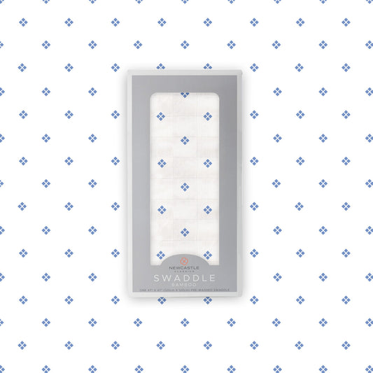 Flat lay of the Newcastle Classics Periwinkle Diamond Polka Dot bamboo muslin swaddle blanket shown with its branded packaging box in the center.