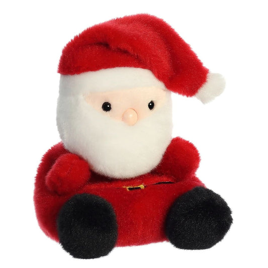 Aurora 5-inch Palm Pals Santa Claus plush toy sitting at an angle showing its vibrant red suit, thick white fluffy beard, floppy Santa hat, and black boots.