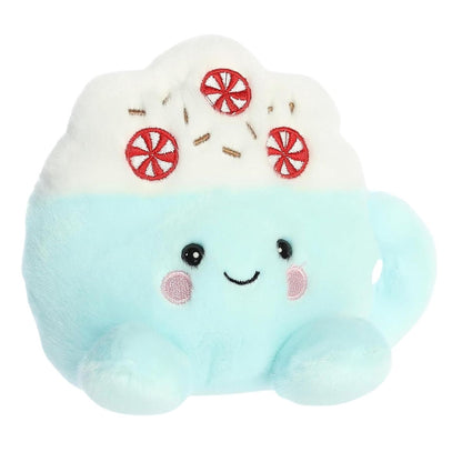 Aurora 5-inch Palm Pals Piper Peppermint Latte plush toy showing its mint-blue mug base with a smiling face, rosy pink cheeks, and white whipped cream top adorned with embroidered peppermint candies and brown sprinkles.