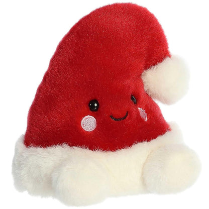 Aurora 5-inch Palm Pals Topper Santa Hat plush toy showing its crimson-red body, fluffy white trim brim, soft white pom-pom tip, and sweet smiling face with rosy cheeks.