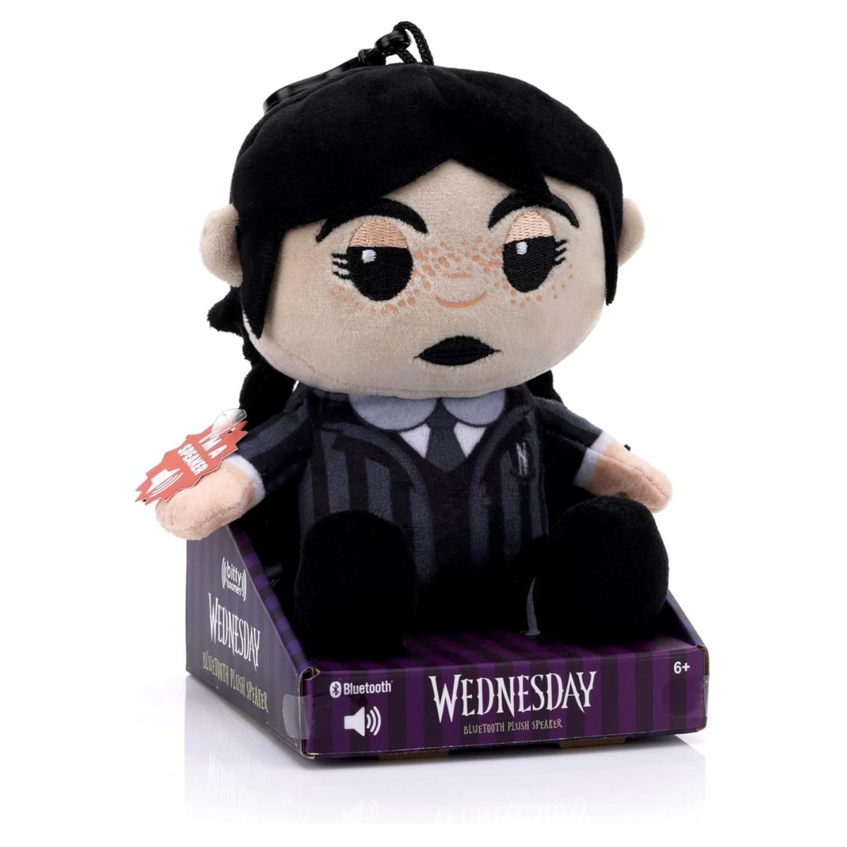 Angled view of the Wednesday Addams plush speaker sitting inside its official purple display box.
