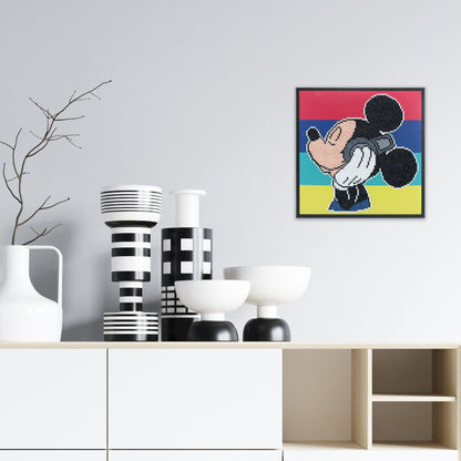 Completed Mickey Mouse Headphones diamond painting displayed as framed wall art in a modern living space above a white credenza.
