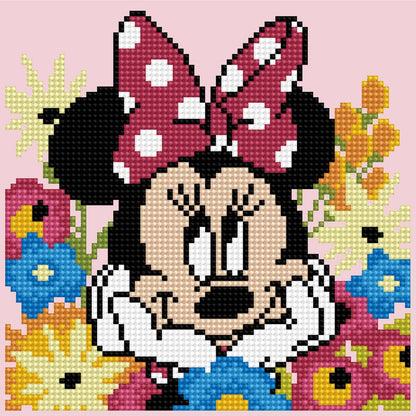 Finished DIAMOND DOTZ Disney Minnie Mouse Daydreaming diamond painting featuring Minnie surrounded by colorful blue, yellow, and pink flowers.