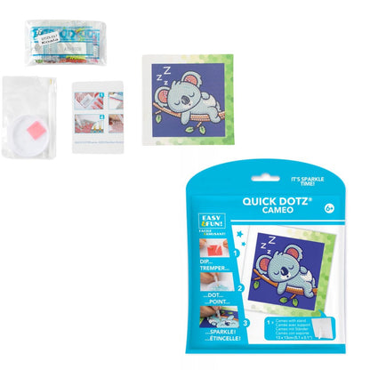 Contents of the DIAMOND DOTZ Quick DOTZ Sleepy Koala kit, including the canvas board, blue retail packaging, colorful diamond drills, and crafting tools.