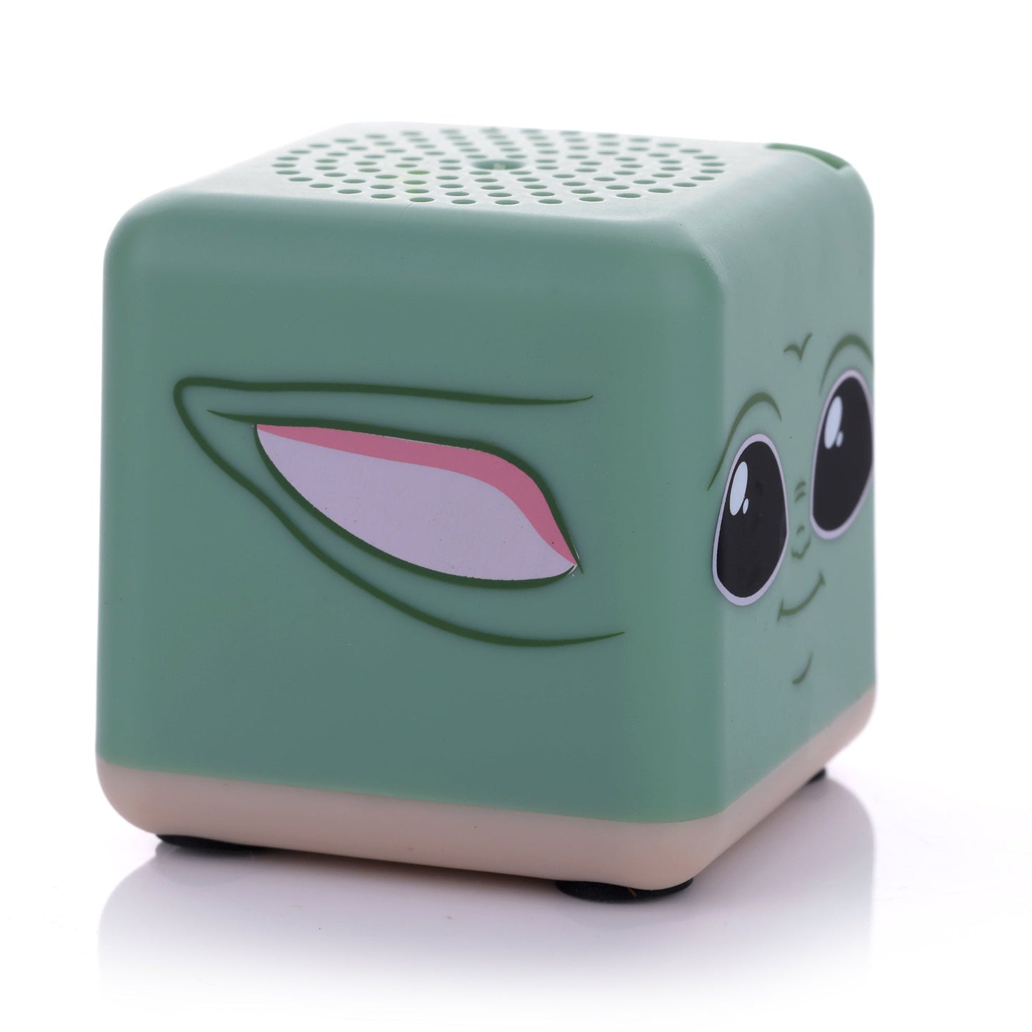 Angled left view of the square Grogu mini speaker showing his signature large ear printed on the side and a tan base.