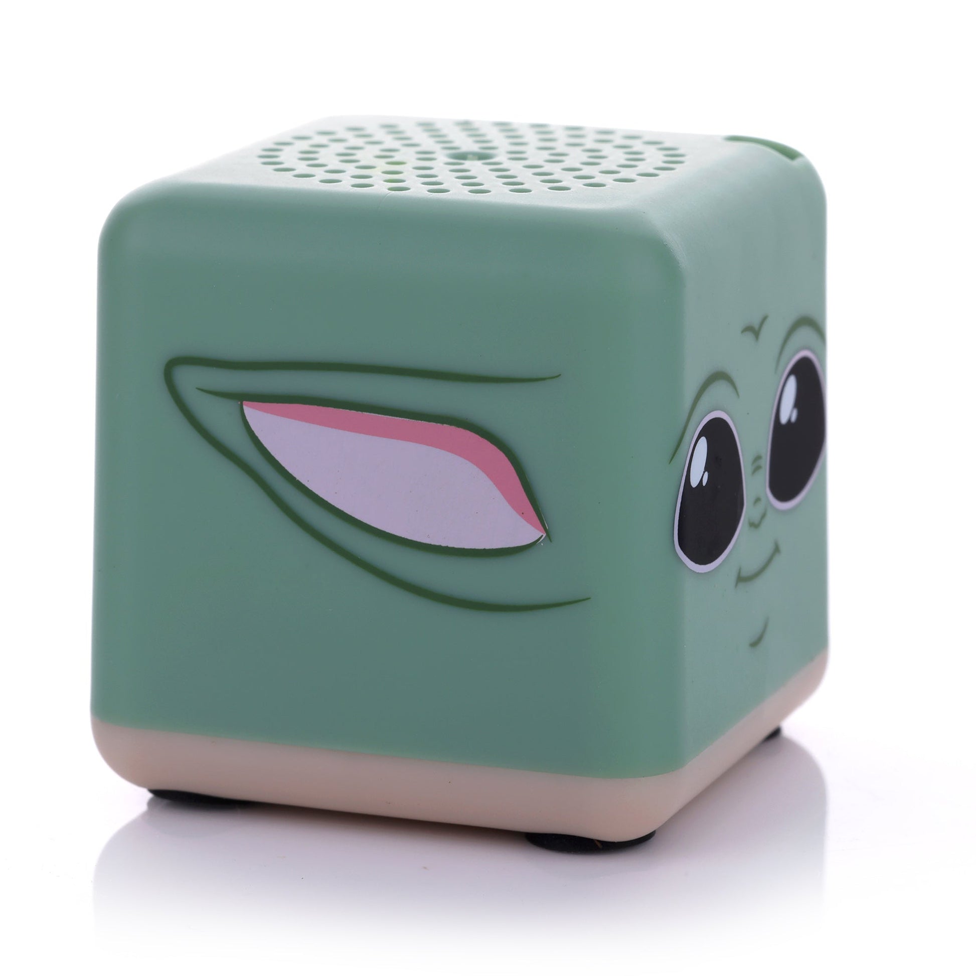 Angled left view of the square Grogu mini speaker showing his signature large ear printed on the side and a tan base.