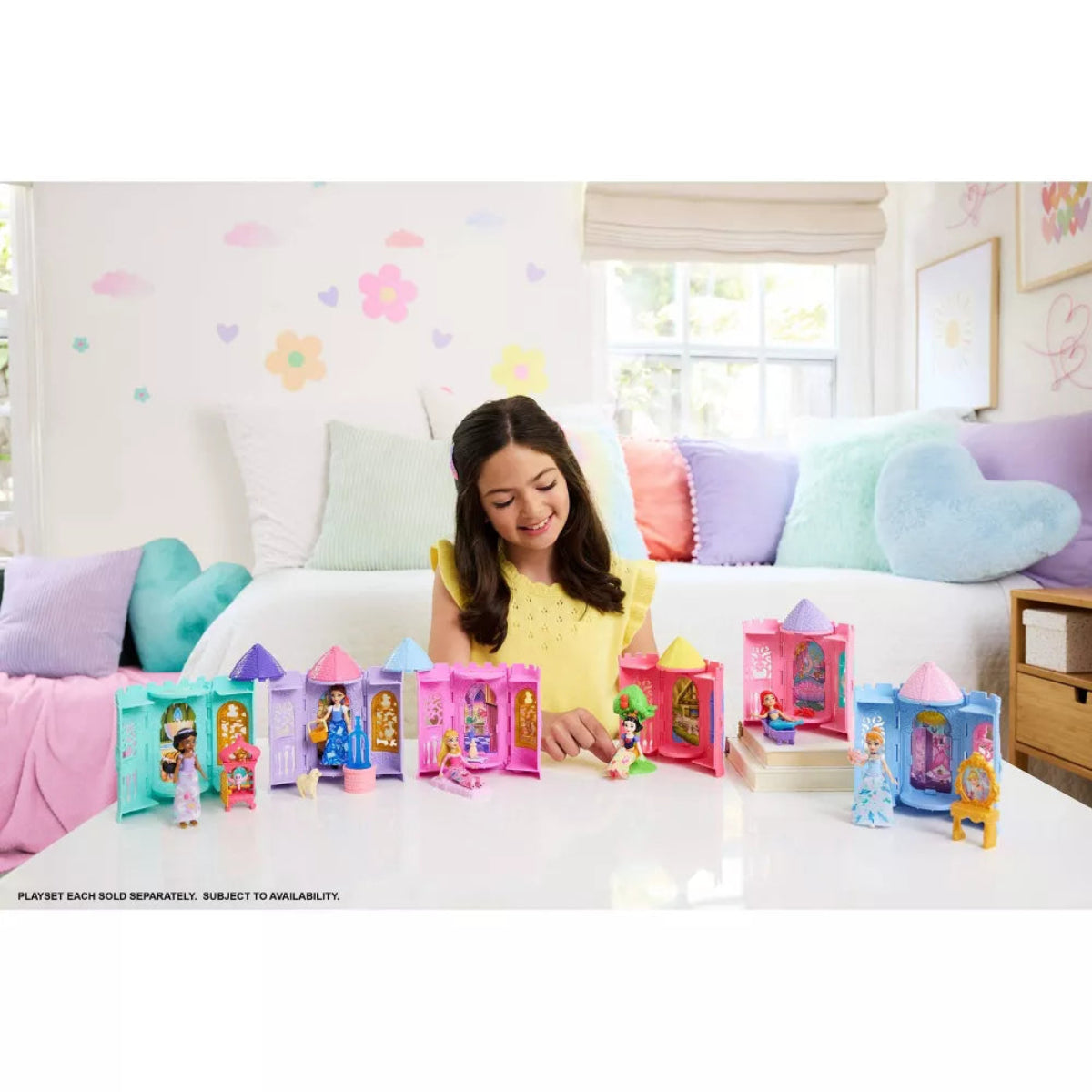Girl playing with toy castle set on a bed in a colorful room