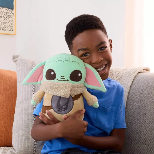 A happy young boy hugging the soft Grogu plush doll, demonstrating its huggable size and kid-friendly design.
