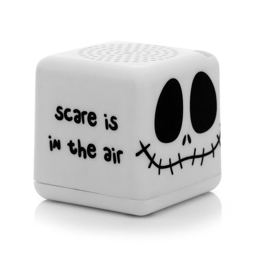 Angled left view of the square Jack Skellington mini speaker showing the phrase 'scare is in the air' written in black spooky font.