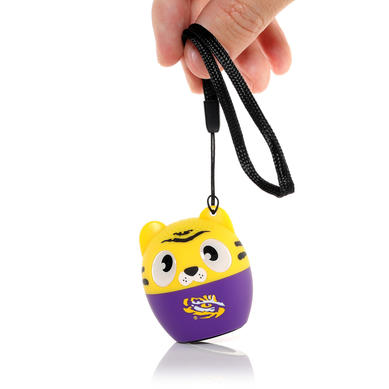 A hand holding the Bitty Boomers LSU Tigers mini Bluetooth speaker by its included black lanyard carrying strap.