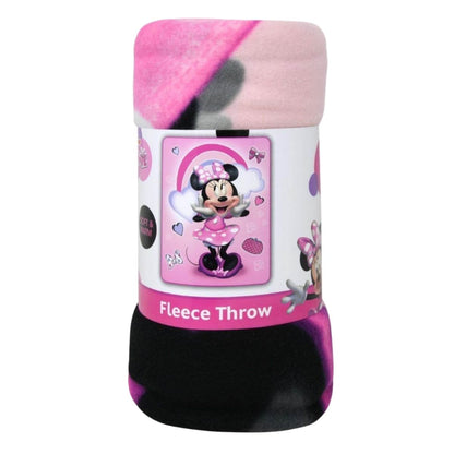 Close-up view of the rolled-up Disney Minnie Mouse fleece throw blanket showing its soft pink and black texture and the printed packaging band.