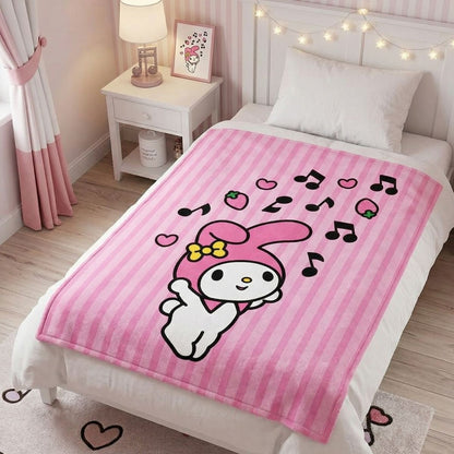 Lifestyle bedroom shot showing the pink My Melody blanket draped beautifully over a bed with cozy decor.