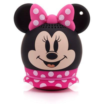 Front view of the Bitty Boomers Disney Minnie Mouse mini Bluetooth speaker featuring her smiling face, a pink polka dot bow, and a pink ruffled skirt base.