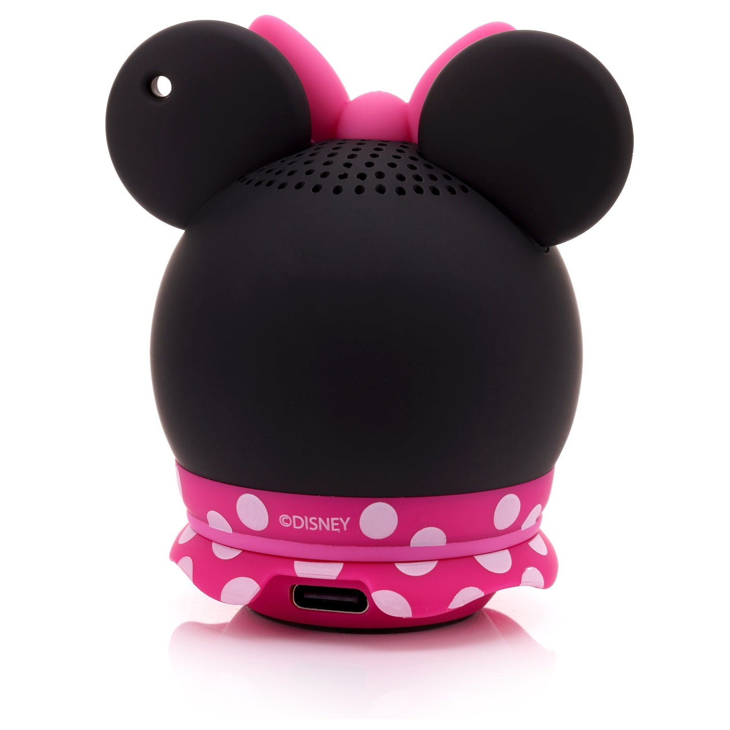 Back view of the Minnie Mouse speaker showing the solid black back, lanyard attachment hole on the ear, pink polka dot skirt, and lower charging port.