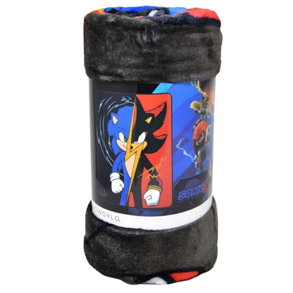 Close-up view of the rolled-up Sonic vs. Shadow silky fleece throw blanket showing its soft dark texture and the printed packaging band.