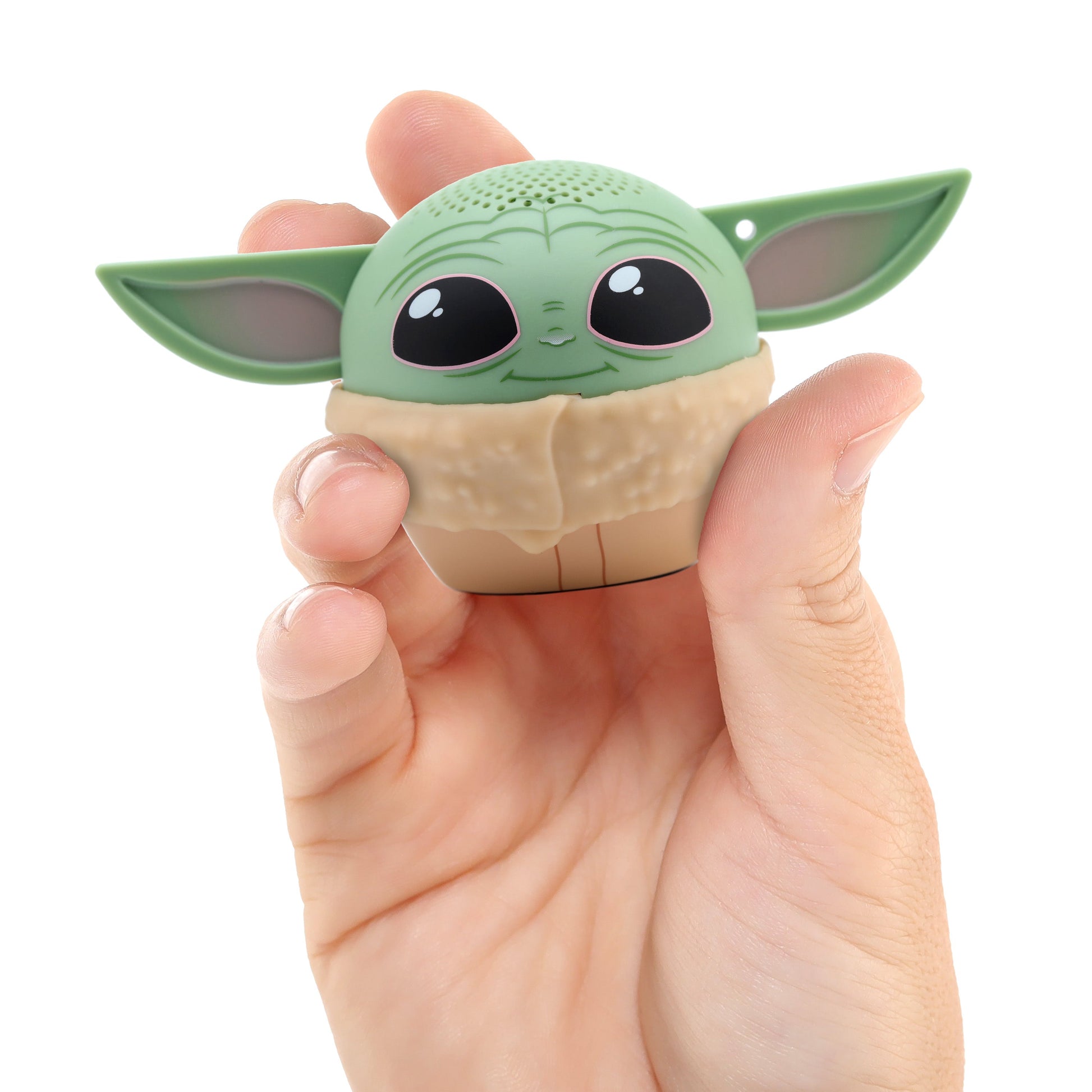 A hand holding the Bitty Boomers Grogu mini Bluetooth speaker, demonstrating its ultra-portable, 2-inch pocket size.