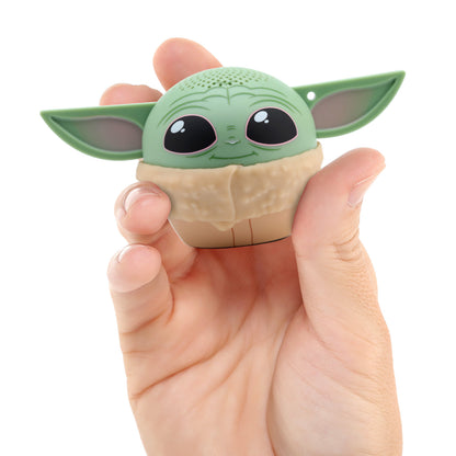 A hand holding the Bitty Boomers Grogu mini Bluetooth speaker, demonstrating its ultra-portable, 2-inch pocket size.