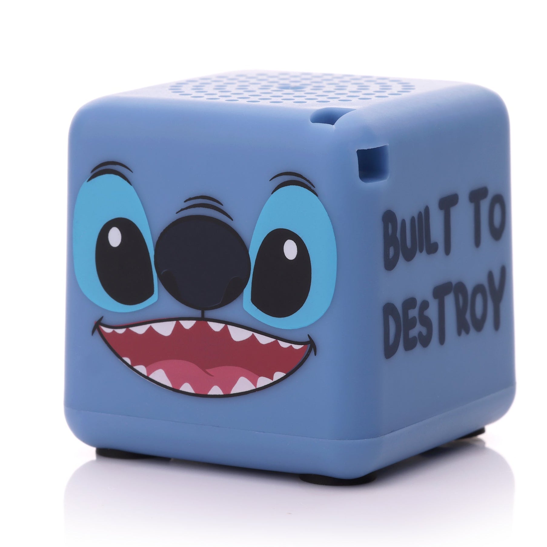 Angled front-right view of the cube-shaped Stitch mini speaker highlighting his toothy grin and the text on the side.
