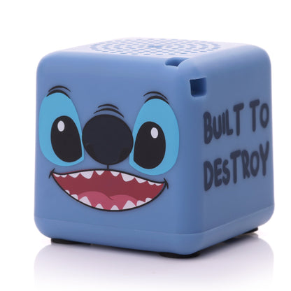 Angled front-right view of the cube-shaped Stitch mini speaker highlighting his toothy grin and the text on the side.