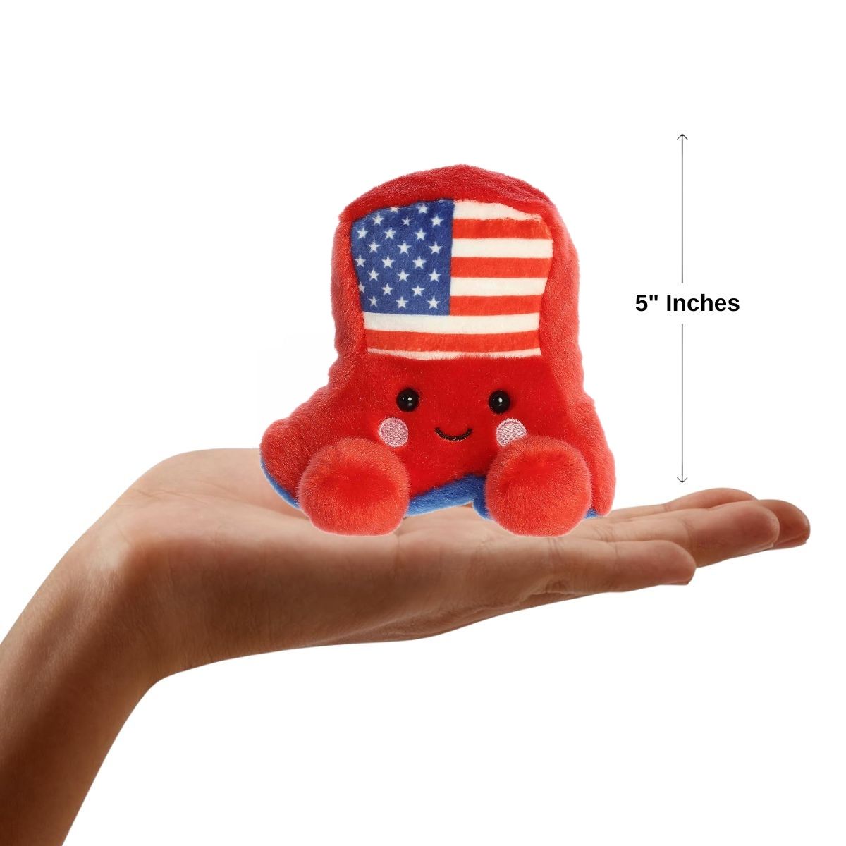 Small plush toy with American flag design held in a hand, showing its size.