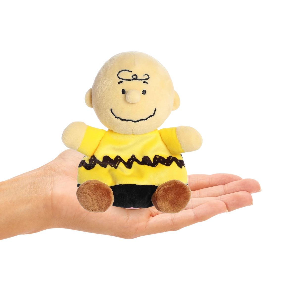 Charlie Brown 5-inch Palm Pals plush sitting in the palm of an open hand showing compact scale.