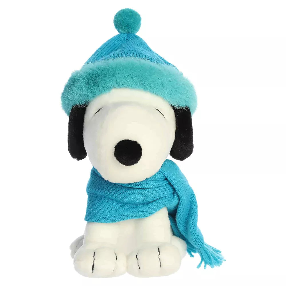 Head-on front seated view of Aurora Peanuts Snoopy plush in teal knit hat with pom-pom and wrapped scarf.