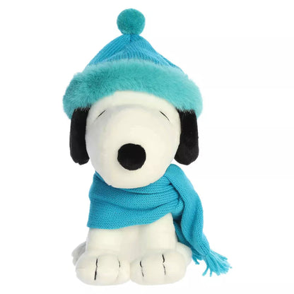 Head-on front seated view of Aurora Peanuts Snoopy plush in teal knit hat with pom-pom and wrapped scarf.