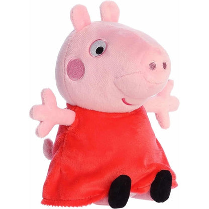 Angled front view of the Aurora Peppa Pig stuffed animal wearing a red dress and black shoes.