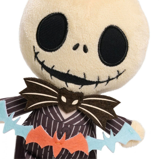 Close-up view of Disney Jack Skellington 7-inch mini plush showing embroidered face, bat tie, and bat banner.