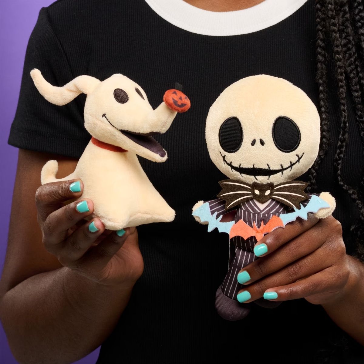 Person holding Disney Halloween Zero 7-inch mini plush next to Jack Skellington plush.