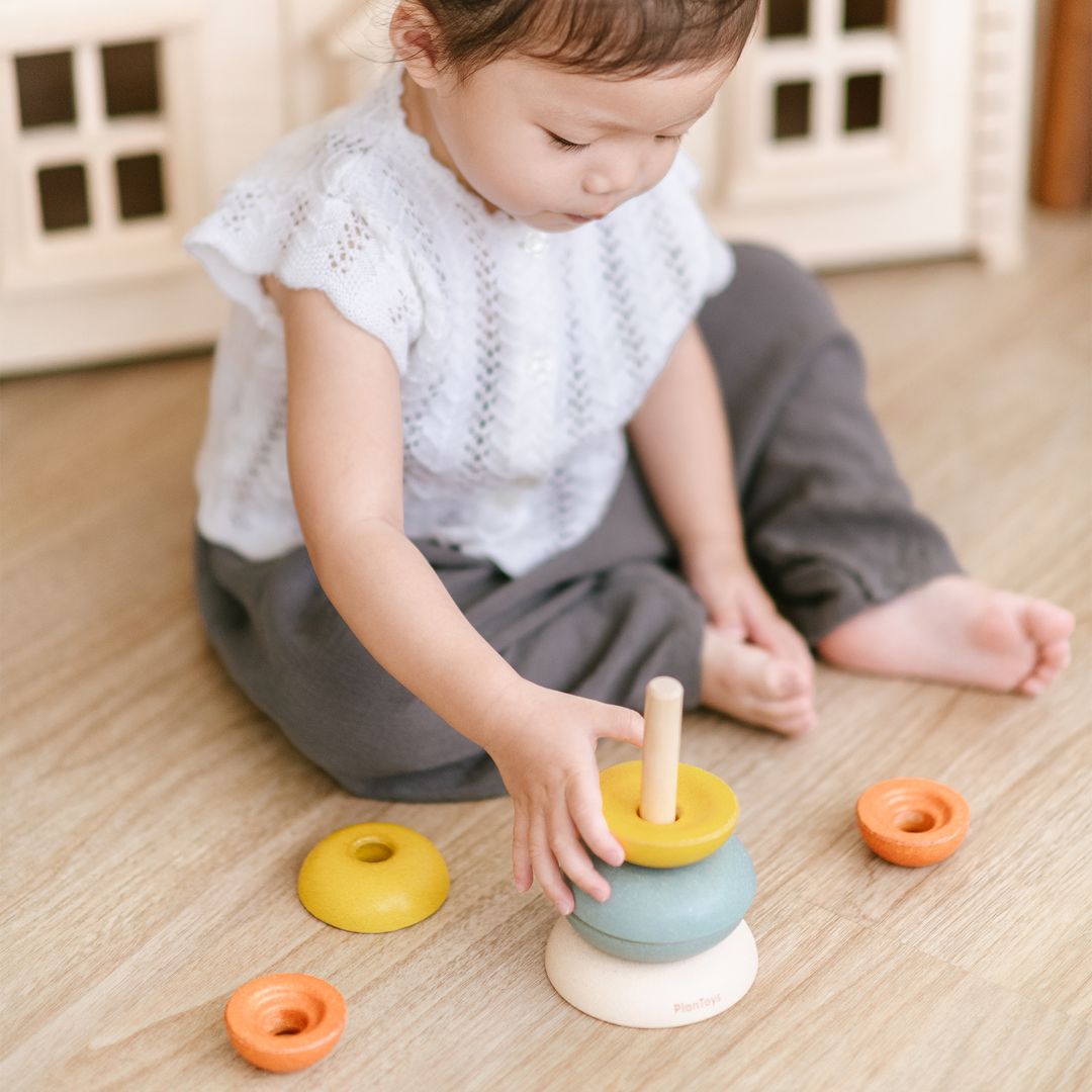 Natural wooden base and center stacking post of the PlanToys activity set.
