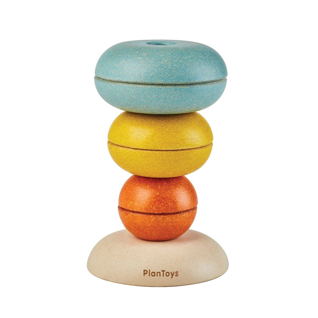 PlanToys wooden stacking rings stacked in an inverted bowl tower shape.