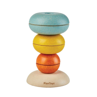PlanToys wooden stacking rings stacked in an inverted bowl tower shape.