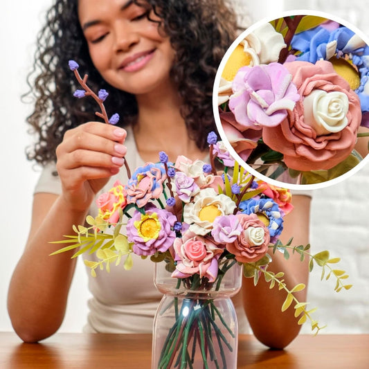 Woman placing completed Play-Doh flower blooms into a clear display vase.