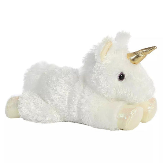 Angled side view of the Aurora Mini Flopsie Celestial Unicorn 8-inch plush resting on its belly, featuring white fur and a metallic golden horn.