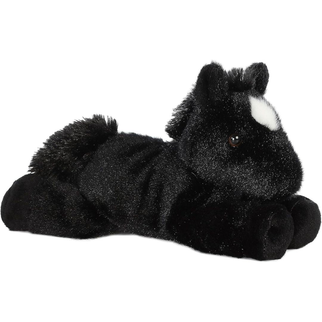 Angled side view of the Aurora Mini Flopsie Beau Black Stallion 8-inch plush resting on its belly, featuring solid pitch-black fur and a white forehead star.