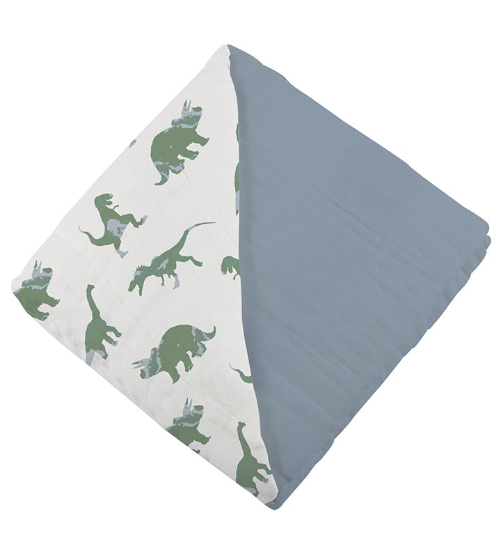 Close-up of the thick, folded multi-layer cotton blanket showcasing the reversible dinosaur and solid slate blue patterns.